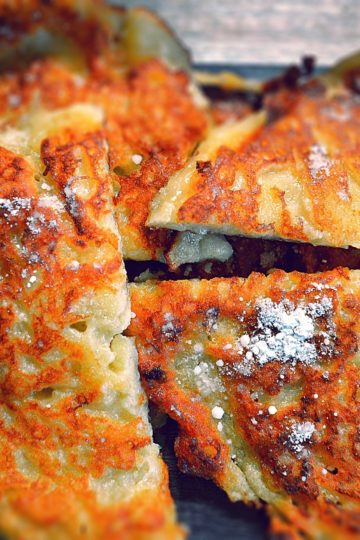 galettes de pommes et farine dorées, coupées en deux, saupoudrées de sucre glace